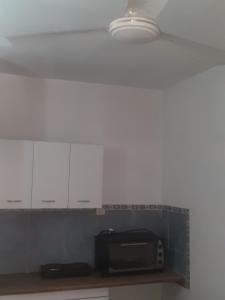 a kitchen with white cabinets and a microwave at HerBer 2 in La Rioja