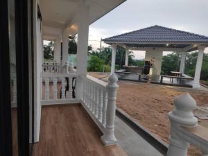 a porch of a house with a white railing at Embun Lodg in Temerloh
