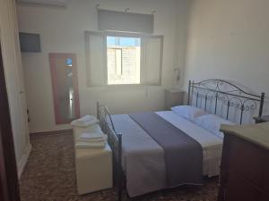 a bedroom with a large bed and a window at Casa del Patriarca - LEUCA- in Marina di Leuca