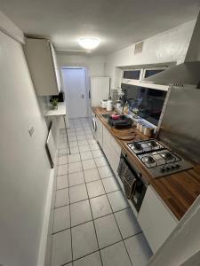 a small kitchen with a stove and a refrigerator at Burlington House - Luxury Home for Contractors in West Bromwich