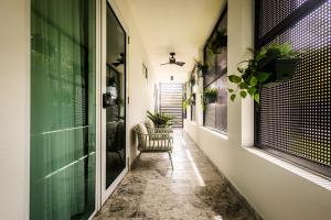 un corridoio con una sedia in una casa di El Gatsby - KingRoom Pool - Resort Vibe Near Beach a San Juan