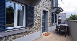 eine kleine Terrasse mit einem Tisch und einem Fenster in der Unterkunft RETIRO Da CALHETA in Estreito da Calheta