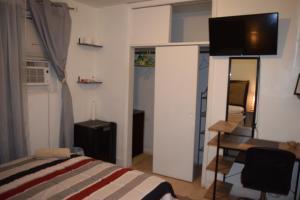 a bedroom with a bed and a desk and a television at Miami Drip Star Life Hostel in Parkway Regional Medical Center Heliport