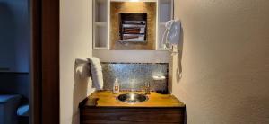 a small bathroom with a sink and a mirror at Cabañas Paso de Viento in El Chalten