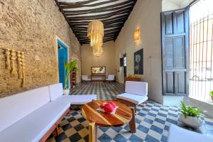 a living room with white furniture and a table at Casona Tres Culturas,steps away from the Convent in Izamal