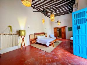 a bedroom with a bed and a red brick floor at Casona Tres Culturas,steps away from the Convent in Izamal +47 photos