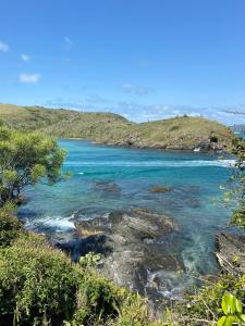 uma vista para uma praia com água azul e árvores em Ap 100 mtrs da praia do forte em Cabo Frio mais 40 fotografias