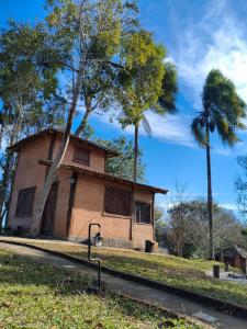 una casa con dos palmeras delante de ella en Chalé aconchegante em Santo Antônio do Pinhal, en Santo Antônio do Pinhal 16 fotos más