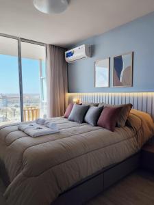 Una cama grande en un dormitorio con una ventana grande. en Departamento en Santa Fe Capital, en Santa Fe