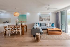 ハミルトン島にあるLagoon Apartments on Hamilton Island by HIHAのソファとテーブルのあるリビングルーム