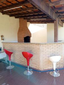 zwei rot-weiße Stühle vor einem gemauerten Kamin in der Unterkunft Pequenino in Sao Jose do Rio Preto