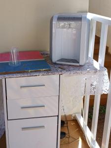 einen Schreibtisch mit einer Mikrowelle und einem Computer darauf in der Unterkunft Pequenino in Sao Jose do Rio Preto