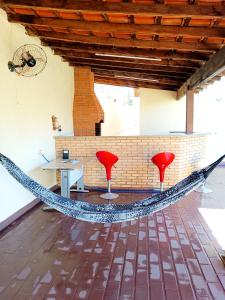 eine Hängematte in einem Zimmer mit 2 Stühlen und einem Tisch in der Unterkunft Pequenino in Sao Jose do Rio Preto