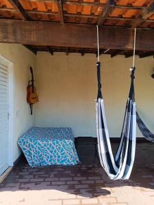 ein Bett und eine Hängematte auf einer Veranda mit einer Gitarre in der Unterkunft Pequenino in Sao Jose do Rio Preto