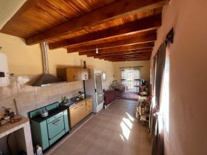 a kitchen with green appliances and wooden ceilings at La Amarilla in Santa María +4 photos