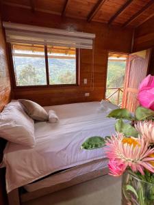 a bed in a room with a window at Nido y Mirador El Condor Sierra Nevada Guican y El Cocuy in Güicán +43 photos