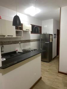 a kitchen with a black counter and a refrigerator at Casa no coração de Lumiar in Nova Friburgo