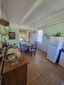 Una cocina y un comedor con una mesa y un refrigerador. en El Carolino, a residence meters from the sea, en Balneario Buenos Aires