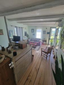 sala de estar con suelo de madera y sofá en El Carolino, a residence meters from the sea, en Balneario Buenos Aires 6 fotos más