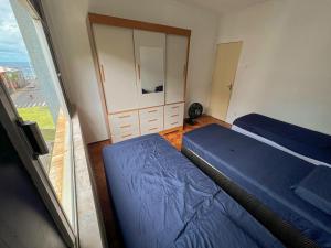 a bedroom with two beds and a large window at Quarto na Pituba in Salvador