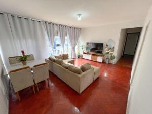 a living room with a couch and a table at Quarto na Pituba in Salvador