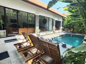 a patio with two chairs and a swimming pool at Villa CRIS - Heart of LEGIAN 3 Bedrooms, 3 Bathrooms in Legian