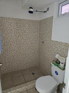a bathroom with a white toilet and a shower at Coban Apartmento in Cobán