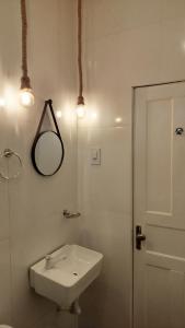 a white bathroom with a sink and a mirror at Vivenda Paz do Jubim in Salvaterra