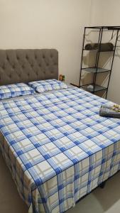 a bed with a blue and white checkered blanket at Vivenda Paz do Jubim in Salvaterra +22 photos