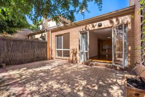 una casa de ladrillo con un patio delante de ella en Inner North Elegance Premier Turner Living 2 Bed, 2 Bath Townhome, en Turner