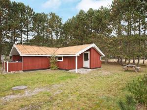 a red shed with a picnic table in a yard at Tranquil Haven near Beach - By Traum Ferienwohnungen in Rødby +33 photos