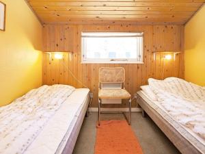 two beds in a room with a chair and a window at Tranquil Haven near Beach - By Traum Ferienwohnungen in Rødby