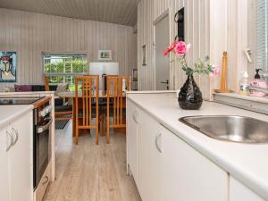 a kitchen with a sink and a vase with a rose at 4 person holiday home in Rønde-By Traum in Rønde +27 photos