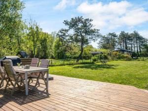 a wooden deck with a table and chairs and a field at 4 person holiday home in Knebel in Knebel