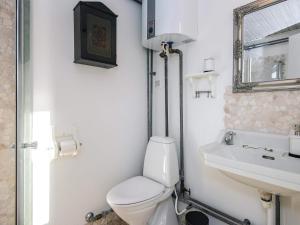 a white bathroom with a toilet and a sink at 4 person holiday home in Knebel in Knebel