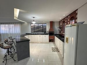 サン・ジョアン・デル・レイにあるApartamento confortável e espaçosoの大きなキッチン(カウンター、冷蔵庫付) +5枚の写真