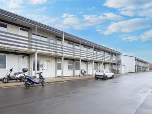 dos motocicletas estacionadas frente a un edificio en 3 person holiday home in Grenaa-By Traum, en Grenå