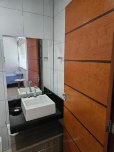 a bathroom with a sink and a mirror at Apartamento no centro in Primavera do Leste
