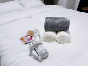 東京にあるサクラシャドウ東池袋の電話とタオルが置かれた白いベッド
