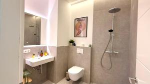a bathroom with a shower and a toilet and a sink at BeckHomes Munich - Stylish Central Apartments in Munich