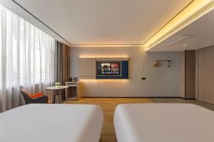 een hotelkamer met twee bedden en een tafel bij Quanli Hotel, Guangzhou Tongde Metro Station Branch in Guangzhou