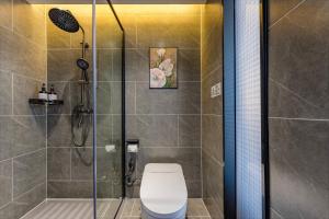 een badkamer met een douche, een toilet en een glazen deur bij Quanli Hotel, Guangzhou Tongde Metro Station Branch in Guangzhou +7 foto's