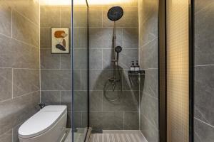 een badkamer met douche en toilet bij Quanli Hotel, Guangzhou Tongde Metro Station Branch in Guangzhou