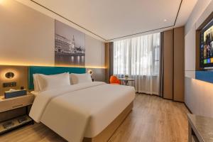 een hotelkamer met een groot bed en een raam bij Quanli Hotel, Guangzhou Tongde Metro Station Branch in Guangzhou