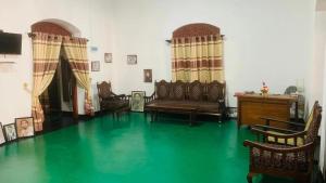 a living room with a green floor and chairs at Walawwa Resort Kurunegala in Kurunegala +10 photos