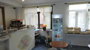a kitchen with a counter with a table and a refrigerator at Hotel Stella Marina in Lerici