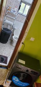 a bathroom with a toilet and a green wall at Appartement Climatisé et Résidence Sécurisée Kribi in Kribi