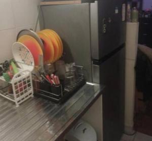 a kitchen counter with a black refrigerator and some dishes at Charmant studio in Paris