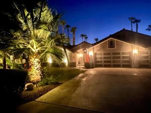 a house with a palm tree in front of a garage at Palm Breezes in Rancho Mirage