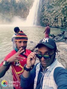 two men standing in front of a waterfall at Pari, Port Moresby in Port Moresby